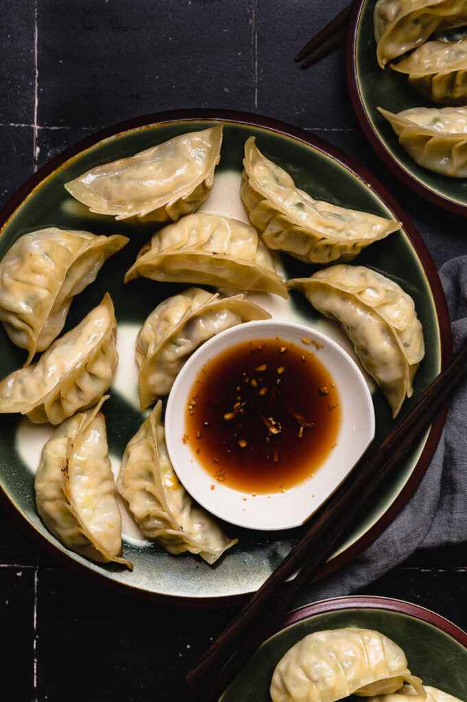 tofu gyoza on a plate with dipping sauce