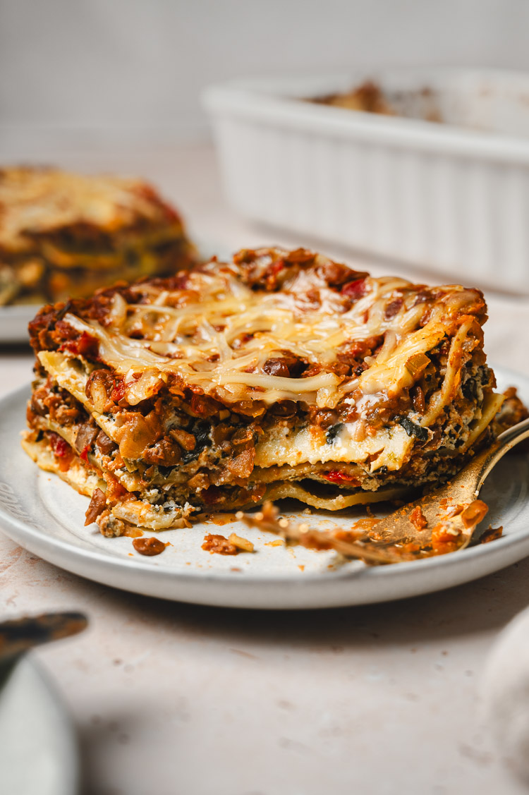 vegan lasagna slice with a bite taken out of it