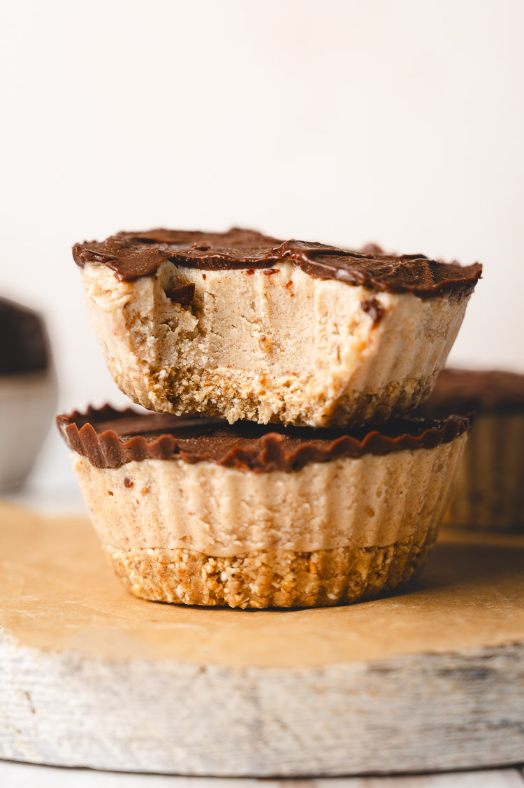 two stacked frozen snickers mousse cups with a bite taken out of the top one